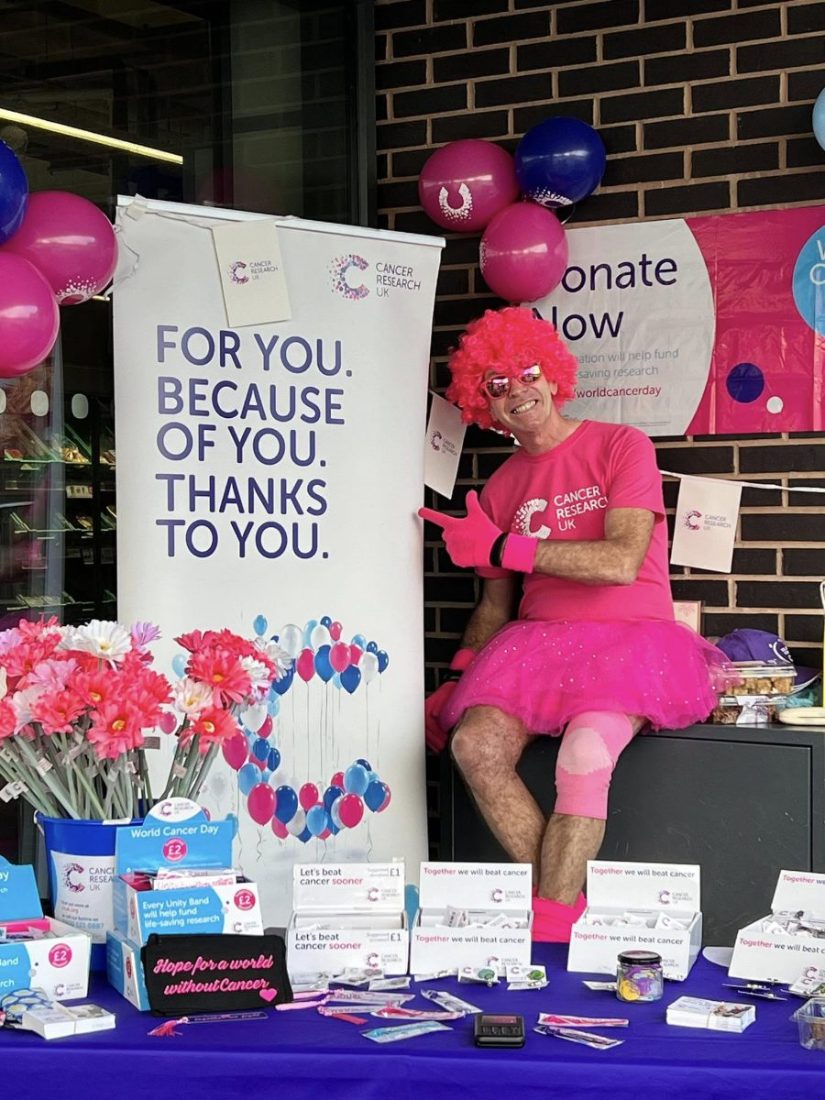 David at a Cancer Research UK stall with collection tins and unity bands
